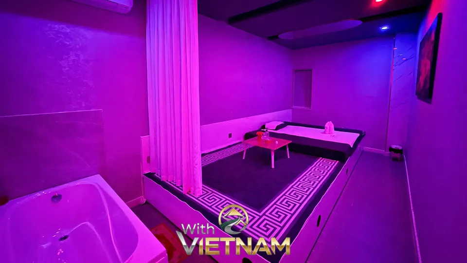 욕조와 침대가 있는 보라색 조명의 스파 룸