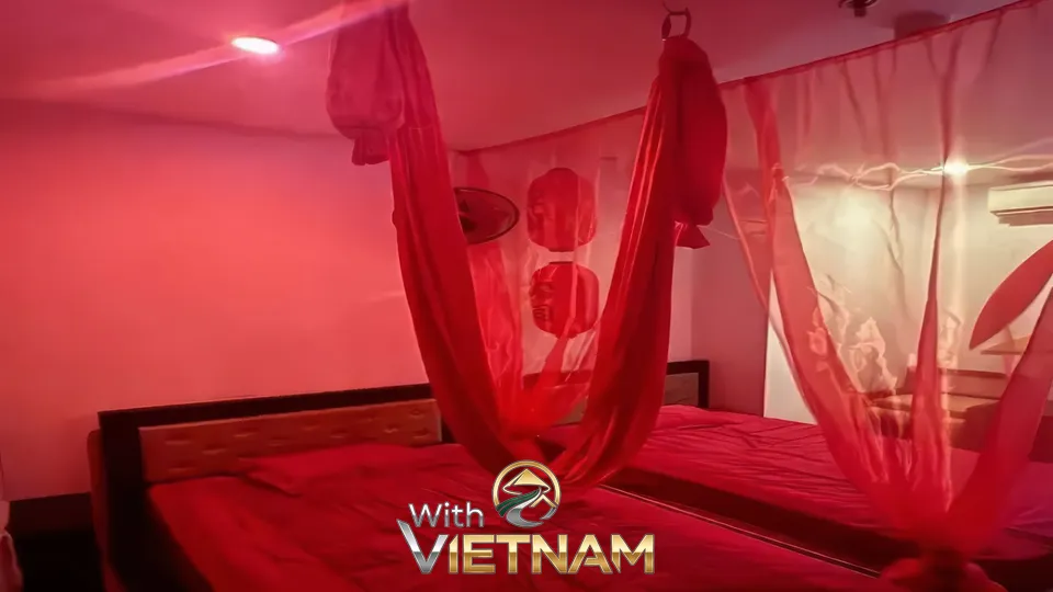 붉은 조명 아래 천이 매달린 침실