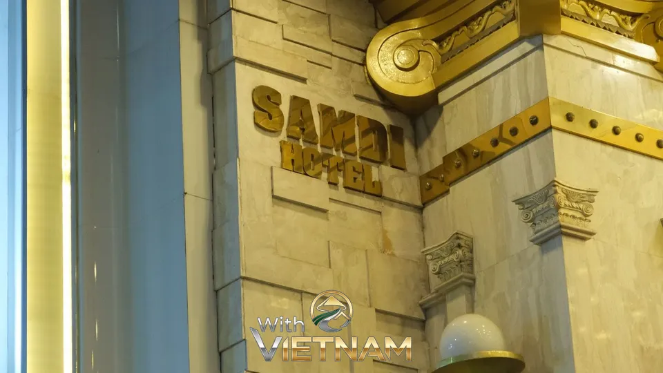 대리석 벽에 부착된 금색 쌈디 호텔 로고