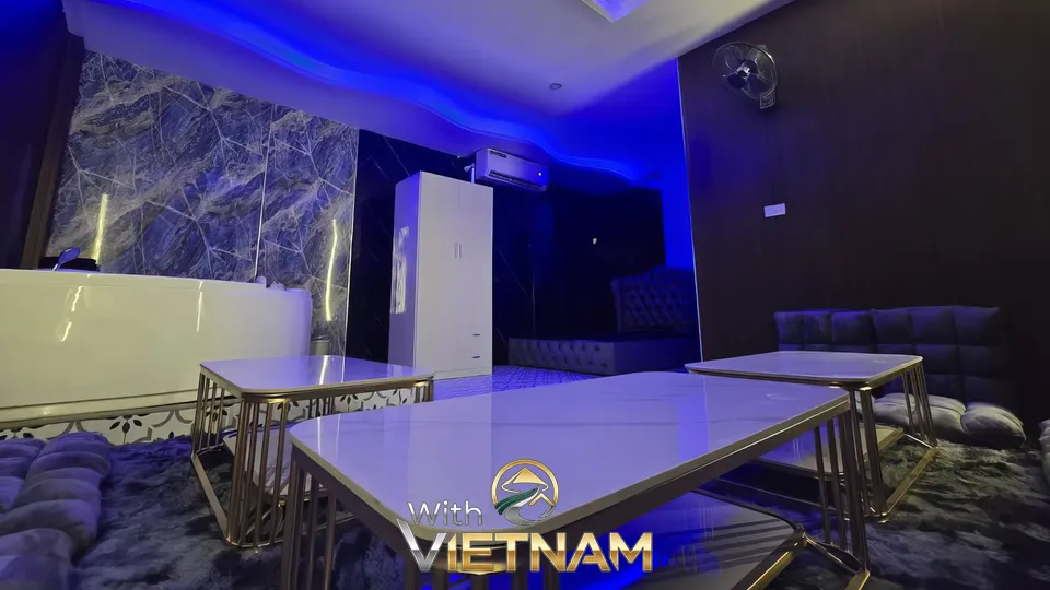 파란색 조명의 욕조와 소파가 있는 방