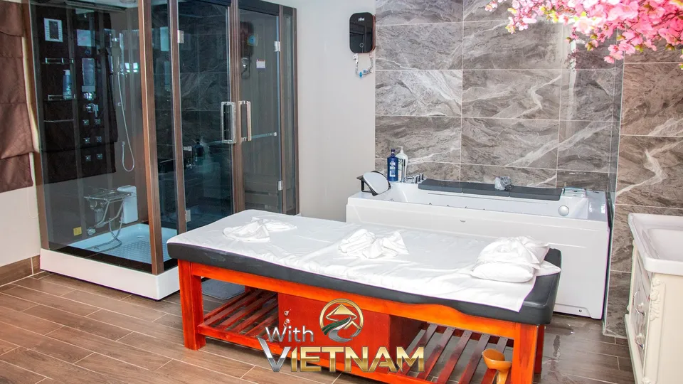 마사지 침대와 욕조 샤워부스가 있는 룸