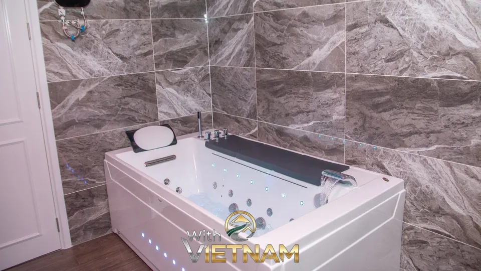 대리석 벽 앞에 놓인 흰색 월풀 욕조