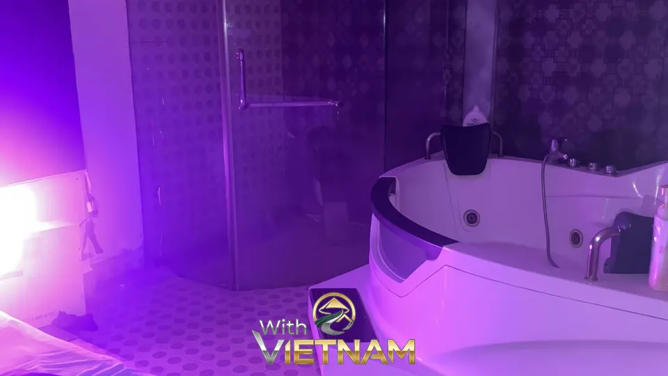 보라색 조명이 비추는 마사지 룸 욕조