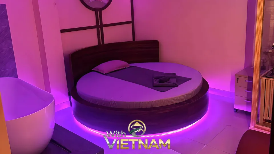 보라색 조명이 켜진 둥근 침대와 욕조